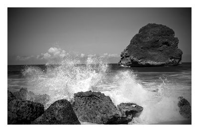 View of rock formation in sea against clear sky