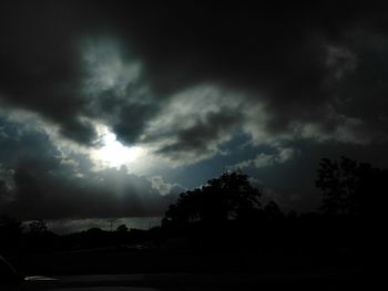 Silhouette trees against cloudy sky