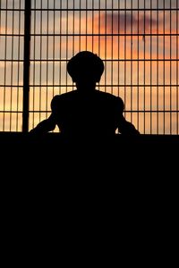 Rear view of silhouette man standing against sky during sunset