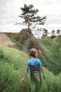 Rear view of woman walking on field