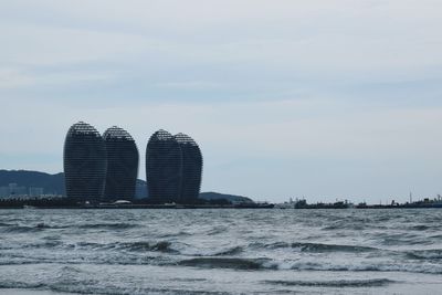 Built structure by sea against sky