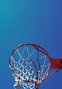 Low angle view of basketball hoop against clear blue sky