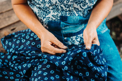 Midsection of woman knitting cloth