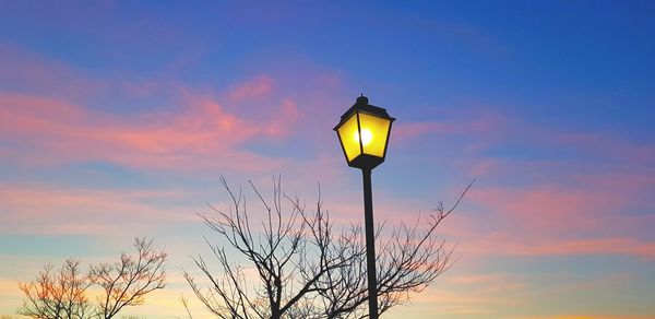 Low angle view of street light against orange sky