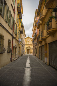 Empty alley amidst buildings in city