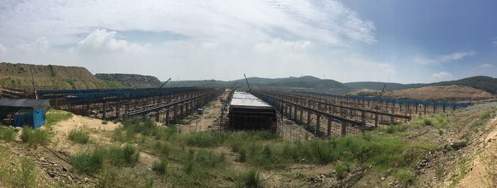 Surface level of bridge against cloudy sky