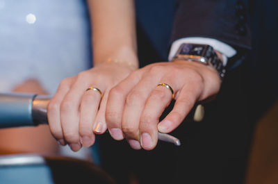 Midsection of couple holding hands