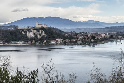 View of townscape by mountain against cloudy sky