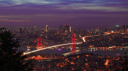 High angle view of illuminated buildings against sky at night