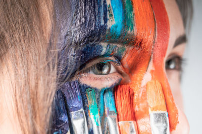 Close-up of young woman painting face