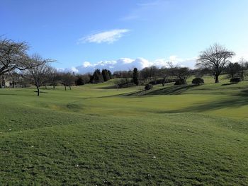 Scenic view of golf course against sky