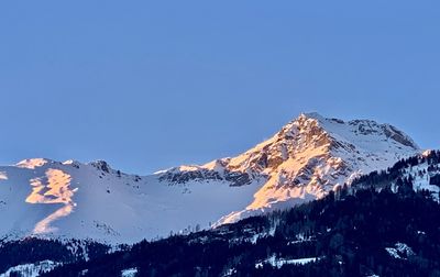 Scenic view of snowcapped mountains against clear blue sky