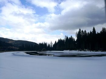 Scenic view of frozen lake against sky during winter