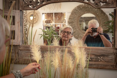 Man photographing thorough mirror