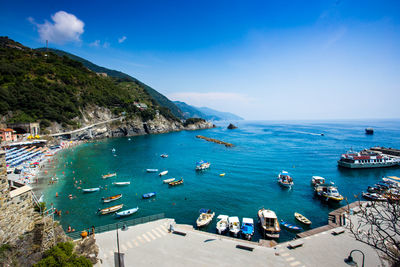 High angle view of boats moored in sea against blue sky