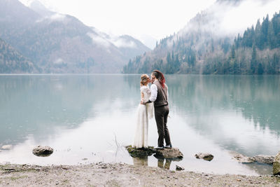 Man standing on lake against mountains