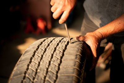 Mechanic changing wheel on car with pneumatic wrench, photo of car wheel.