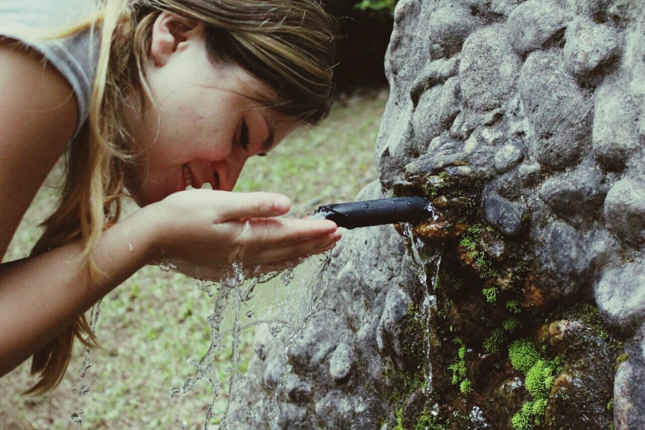 lifestyles, holding, leisure activity, person, young adult, casual clothing, standing, front view, focus on foreground, close-up, day, young women, outdoors, part of, tree, tree trunk, side view