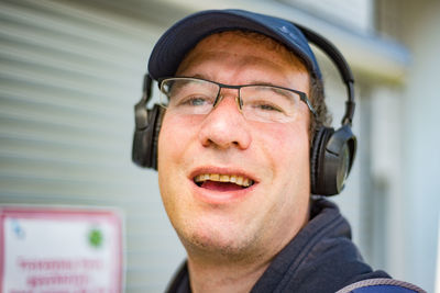 Close-up portrait of smiling man wearing headphones