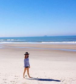 Full length of woman on beach against clear sky