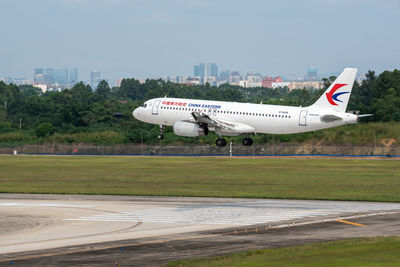 Side view of airplane on airport runway against sky