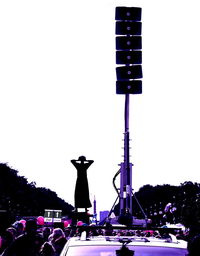 Low angle view of people against clear sky