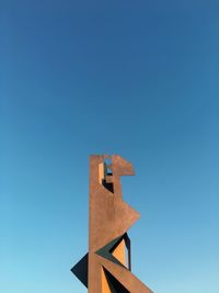 Low angle view of cross against blue sky