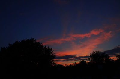 Low angle view of silhouette trees against sky at sunset