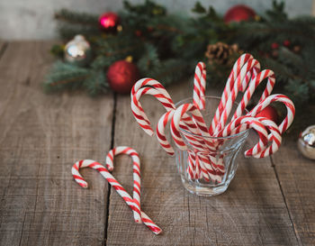 High angle shot of a glass of candy canes against christmas backdrop.