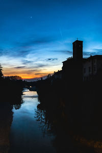 Scenic view of silhouette buildings against sky at sunset