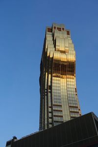 Low angle view of skyscraper against clear blue sky