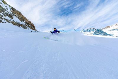 People skiing on snowcapped mountain against sky