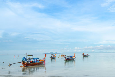 Fishing boats in sea against sky