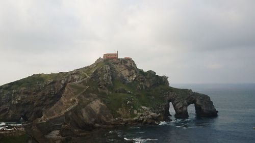 Lighthouse by sea against sky