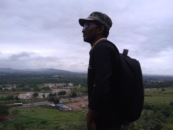 Man looking at cityscape against sky