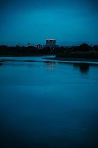 Scenic view of lake against blue sky at dusk