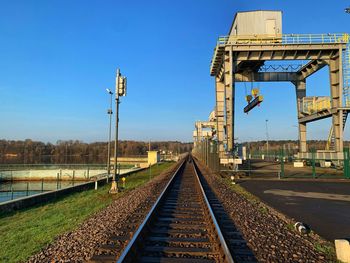 Railroad tracks against clear blue sky