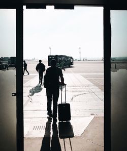 Rear view of men walking in airport