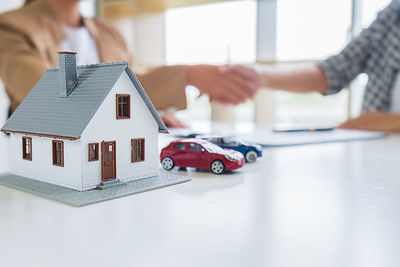 High angle view of hand with toy car outside building