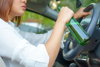 Midsection of woman sitting in car