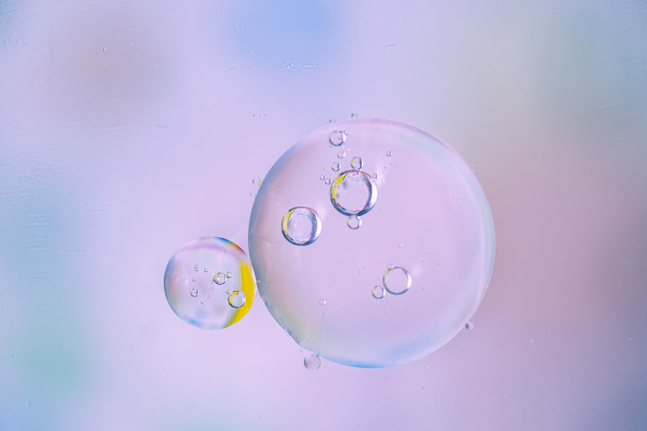 liquid bubble, bubble, circle, drop, water, blue, no people, geometric shape, indoors, macro photography, nature, close-up, shape, colored background, studio shot, fragility, multi colored, transparent, mid-air, wet, motion, simplicity, pink