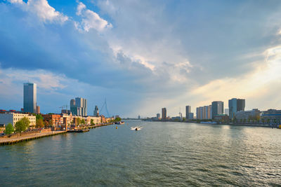 River by buildings in city against sky