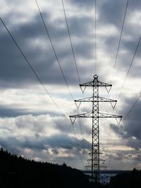 Low angle view of silhouette electricity pylon against sky