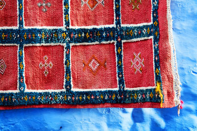 Red fabric drying against blue wall