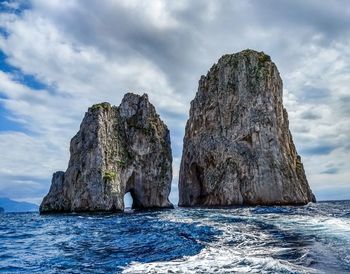 Rocks in sea against sky