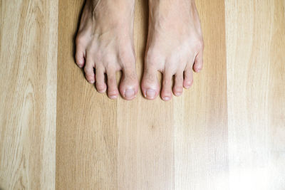 Low section of person on wooden floor