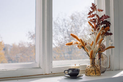 Close-up of flower vase on window sill