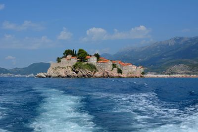 Scenic view of sea and mountains against blue sky