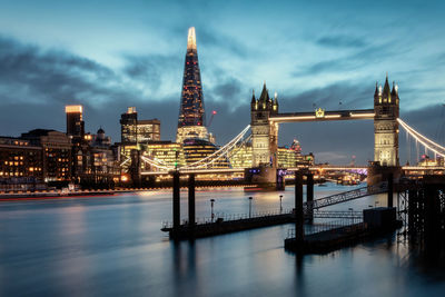 View of illuminated bridge and buildings against sky