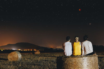 People on field against sky at night